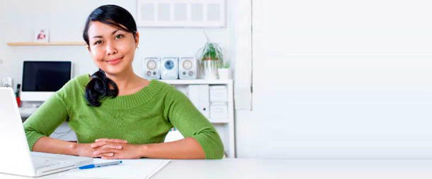 Woman working on a laptop at a desk, representing online career training and education